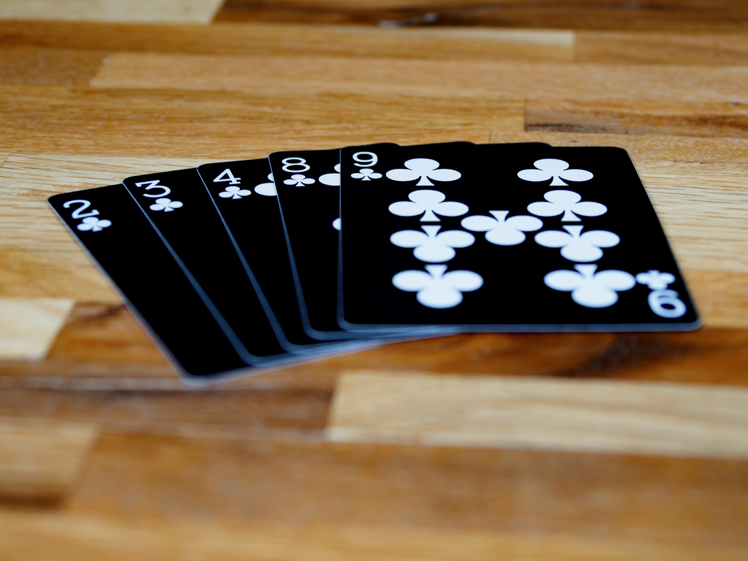Black poker cards on wooden table