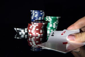 Aces and poker chips on black background