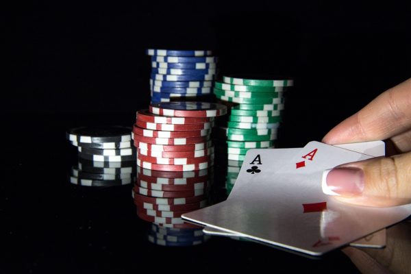 Aces and poker chips on black background