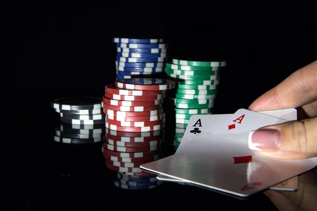Aces and poker chips on black background
